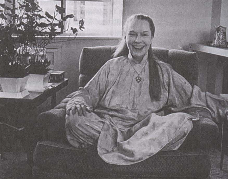 Grayscale Portrait Photo of the actress Louise Brooks in her Later Life, wearing  white dress, sitting on a sofa
