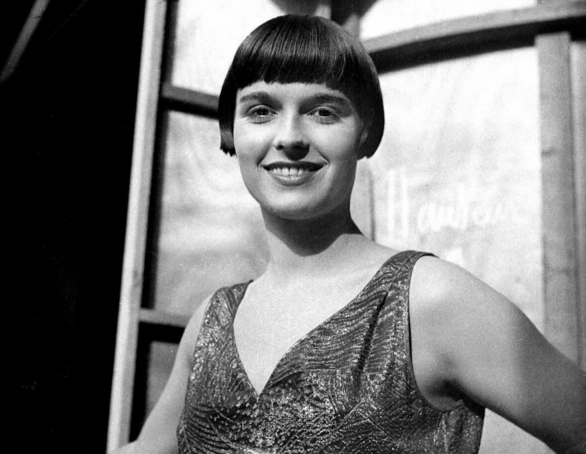 Grayscale Portrait Photo of the actress Louise Brooks, wearing a dark dress