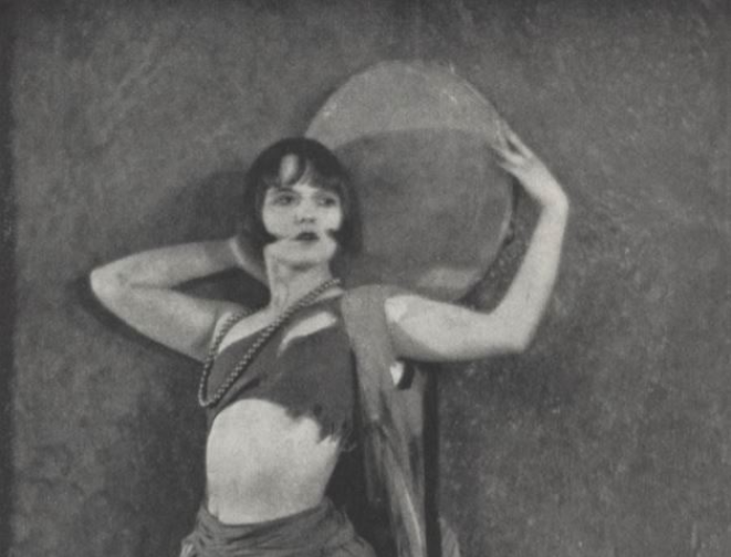 Actress and performer Louise Brooks, on page 20 of the June 1925 Paris Nights, wearing extravagant clothes, with her arms raised