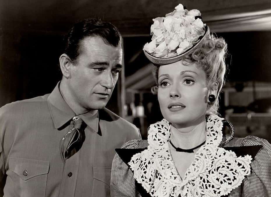 John Wayne and Martha Scott in In Old Oklahoma, standing next to each other