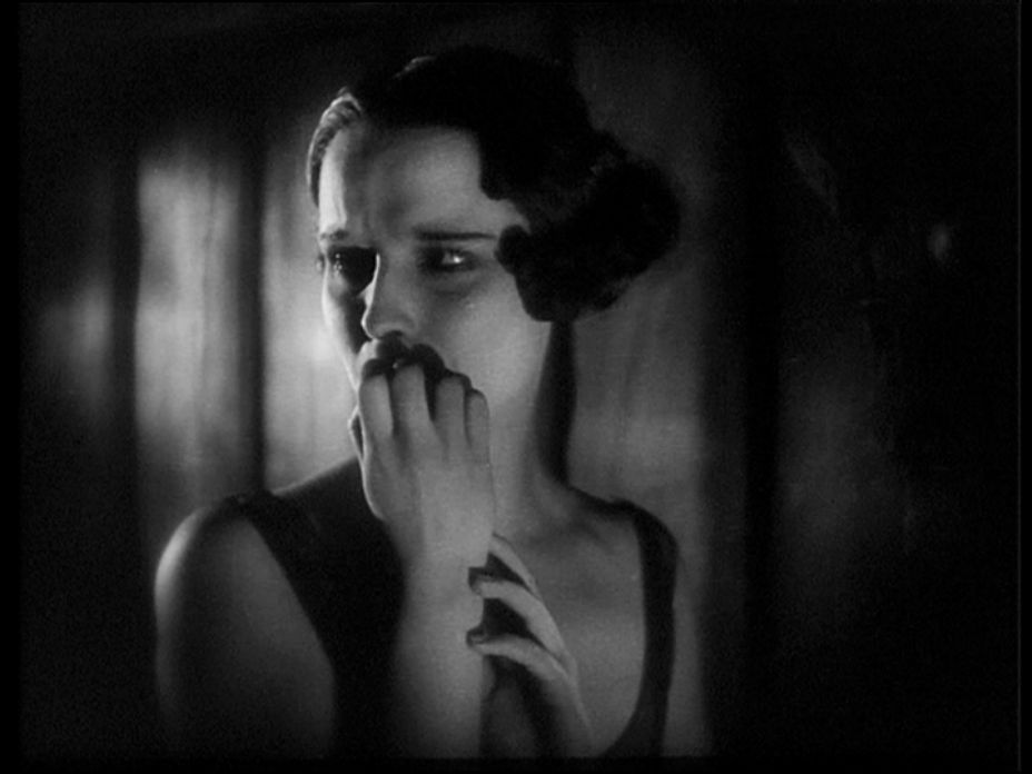 Grayscale Portrait Photo of the actress Louise Brooks, wearing a black dress, looking to the right, sad expression