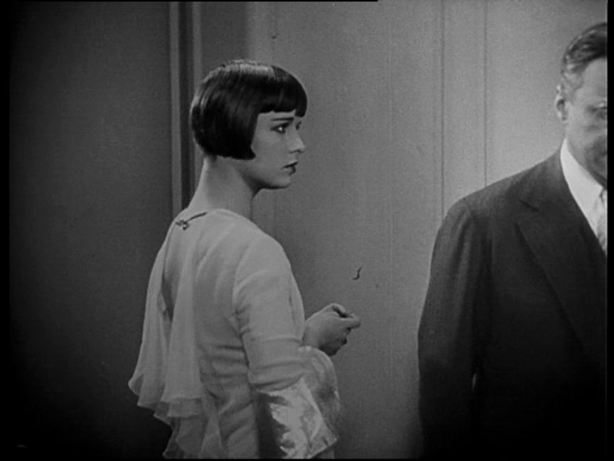 Grayscale Portrait Photo of the actress Louise Brooks from the movie Pandora's Box, wearing white dress, looking to other actor