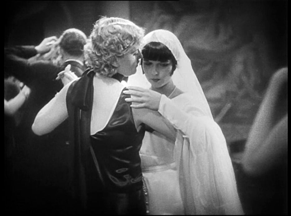 Grayscale Portrait Photo of the actress Louise Brooks from the move Pandora's Box, wearing wedding dress, dances with other actress