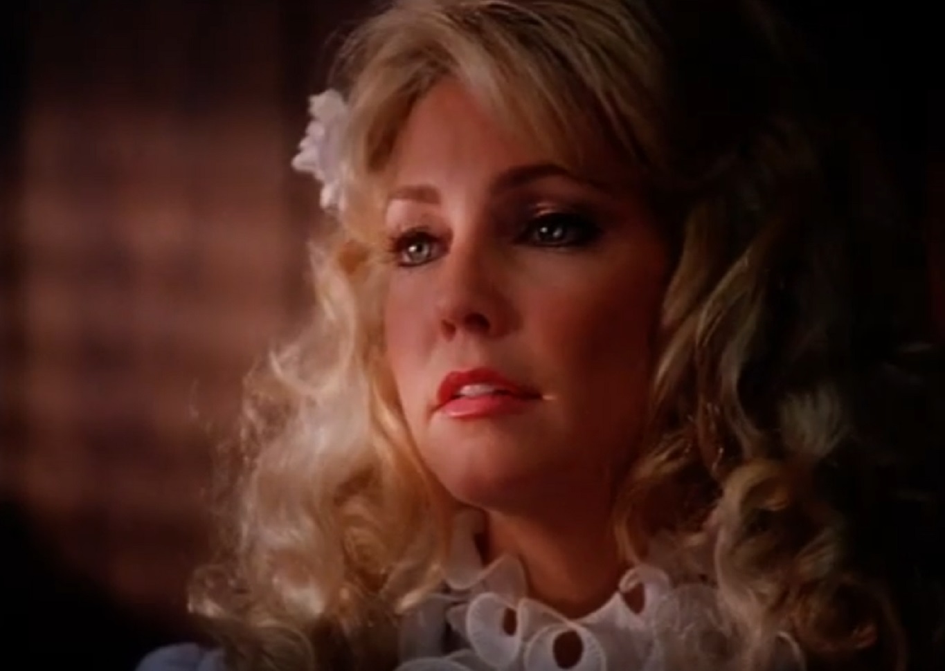 Screenshot of Heather Locklear wearing white dress and looking at side - from Texas Justice (1995)