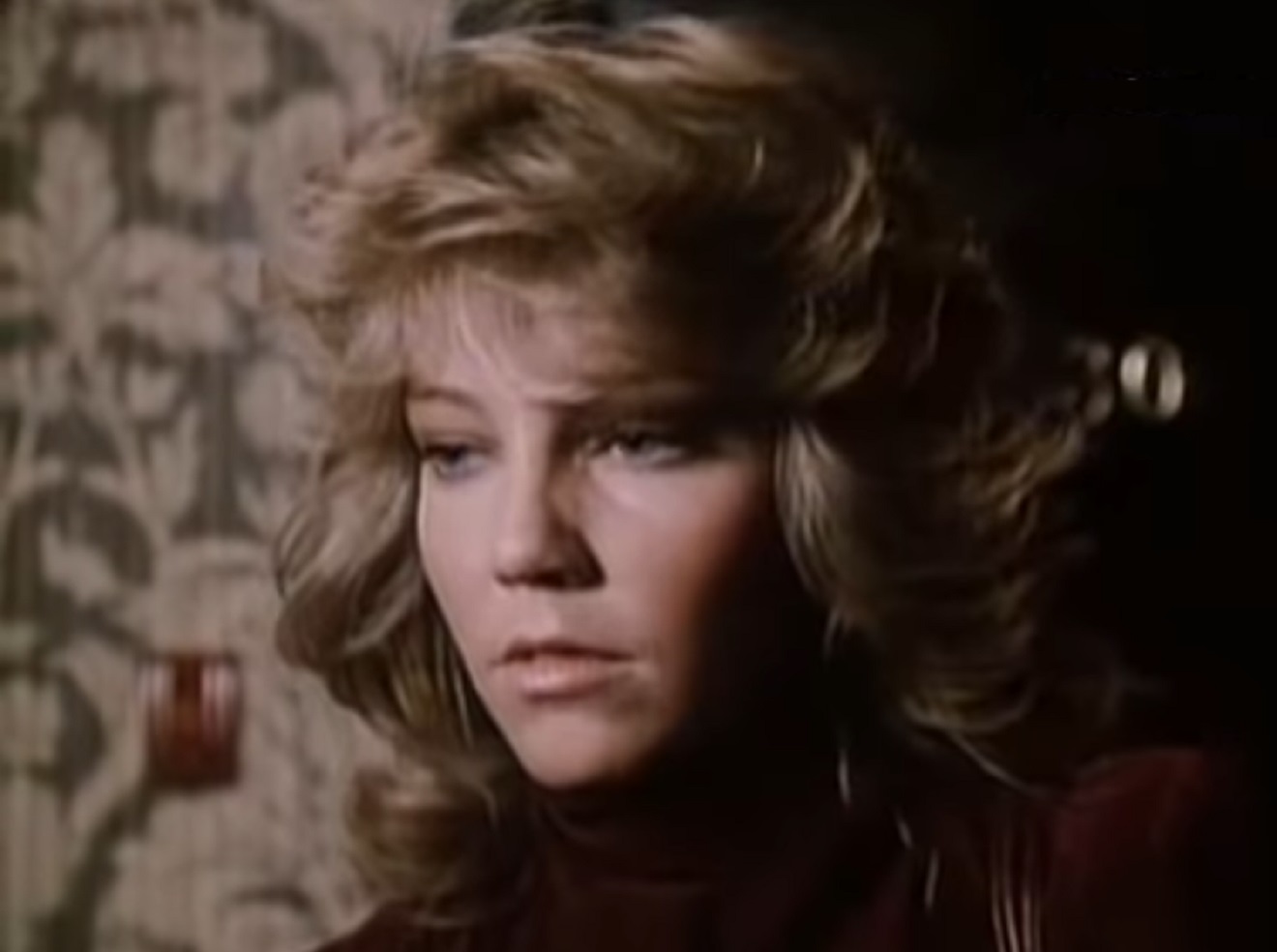 Screenshot of Heather Locklear wearing black sweater is looking at side - from City Killer (1984)