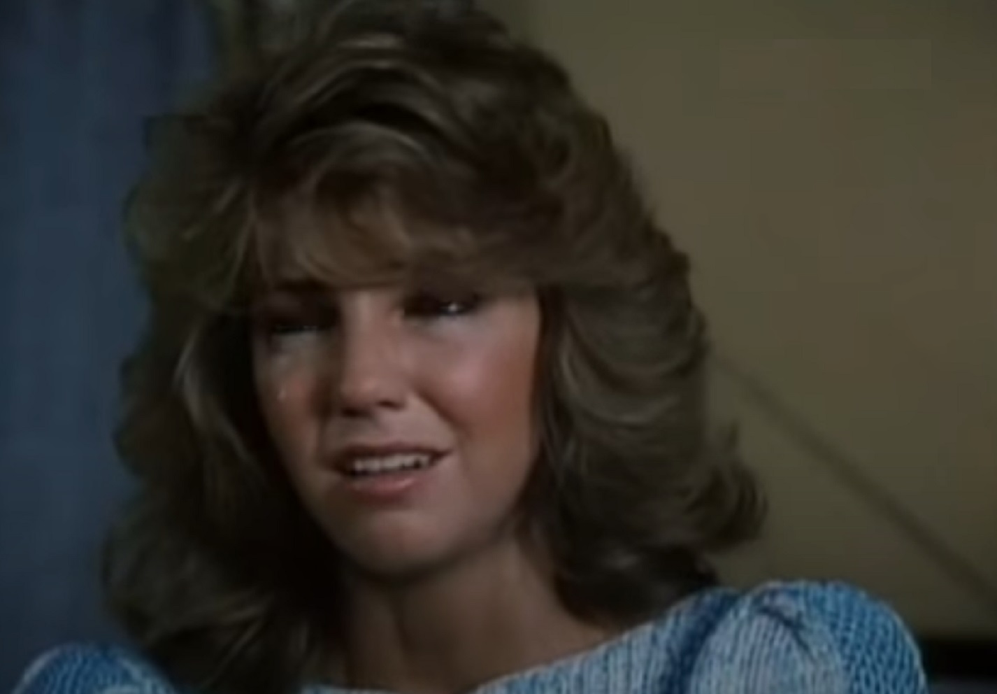 Screenshot of Heather Locklear wearing blue dress and crying - from City Killer (1984)