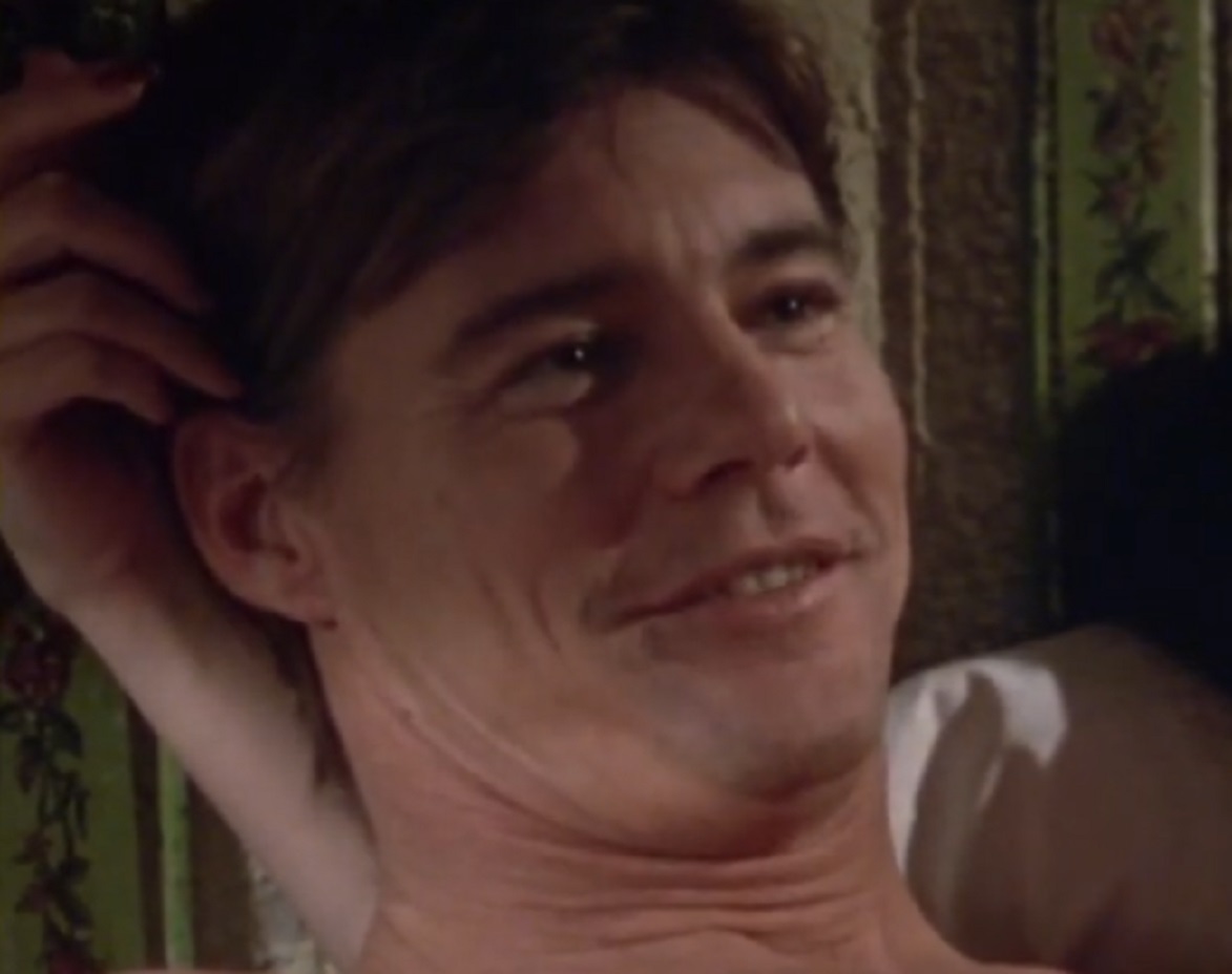 Screenshot: Jan-Michael Vincent laying on the bed is smiling - from Defiance (1980)