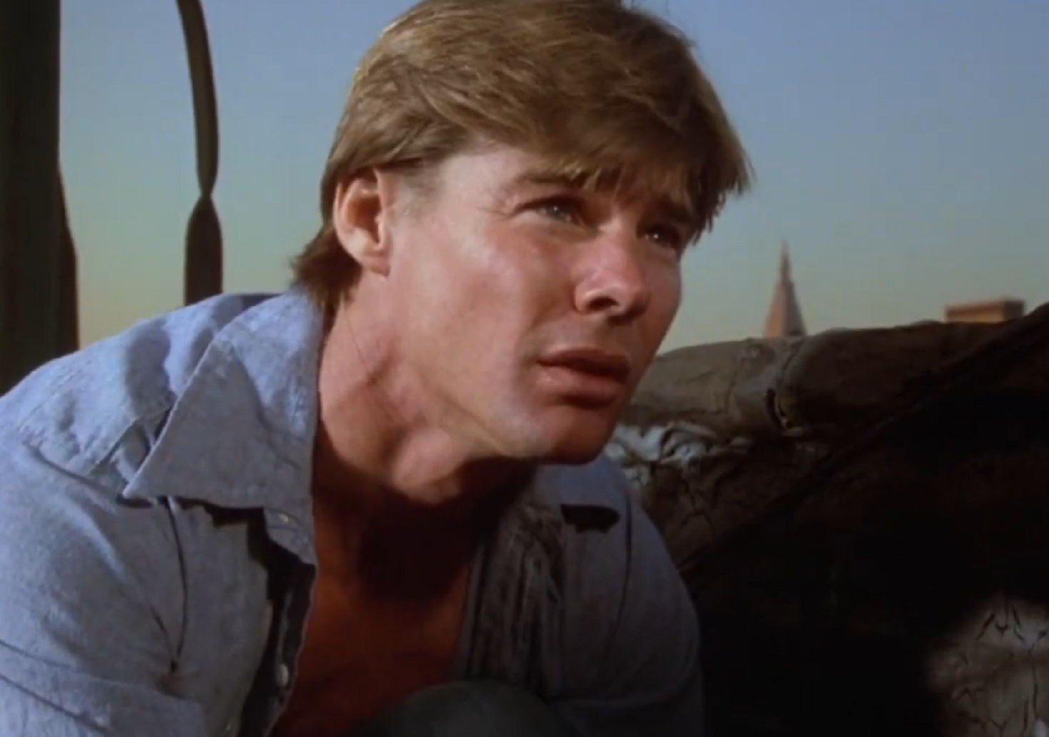 Screenshot: Jan-Michael Vincent wearing blue shirt is looking at side - from  Airwolf (1984/86)