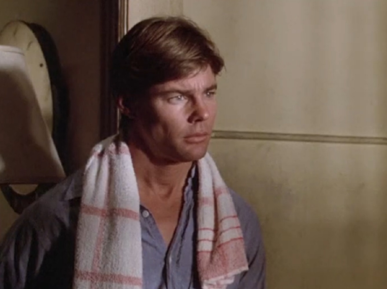 Screenshot: Jan-Michael Vincent wearing blue shirt is looking at front with upset face - from Defiance (1980)