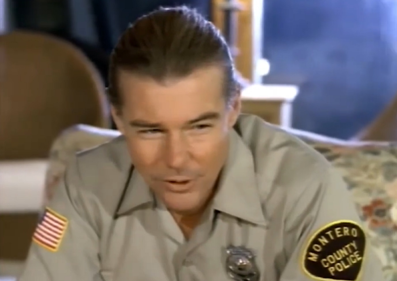 Screenshot: Jan-Michael Vincent wearing police uniform is looking at side - from Hidden Obsession (1993)
