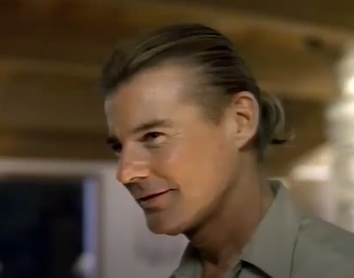 Screenshot: Jan-Michael Vincent wearing grey  shirt is looking at front and smiling - from Hidden Obsession (1993)