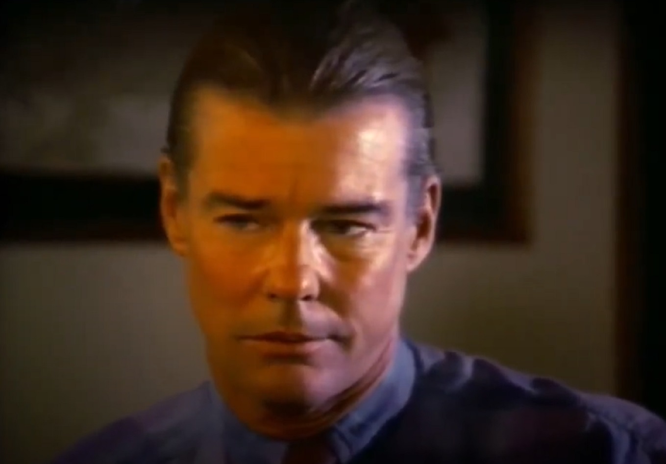 Screenshot: Jan-Michael Vincent wearing blue shirt is looking sad - from Hidden Obsession (1993)