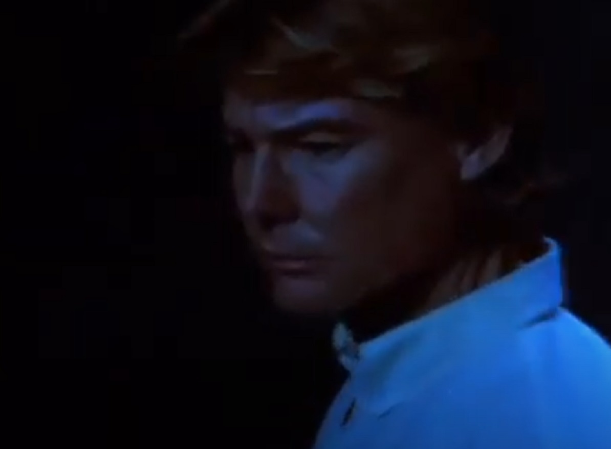 Screenshot: Jan-Michael Vincent wearing white shirt is looking at side in dark  - from Xtro Ii- The Second Encounter (1991)