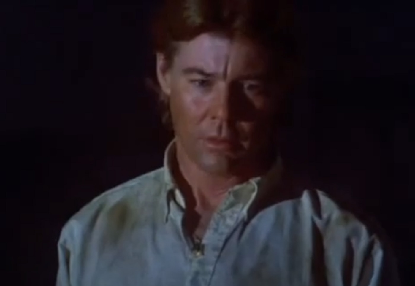 Screenshot: Jan-Michael Vincent wearing filthy shirt is looking down - from Xtro Ii- The Second Encounter (1991)