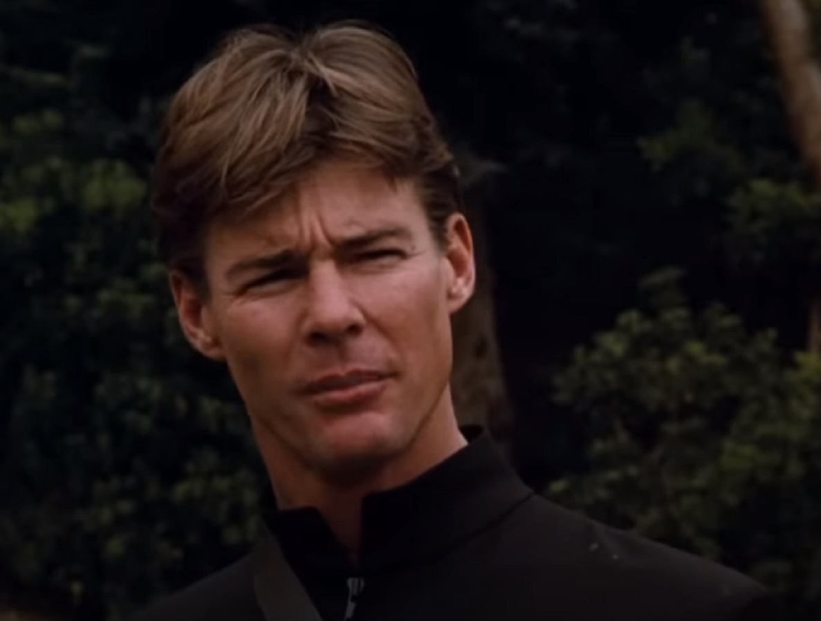 Screenshot: Jan-Michael Vincent wearing black coat is looking at side - from Hooper (1978)
