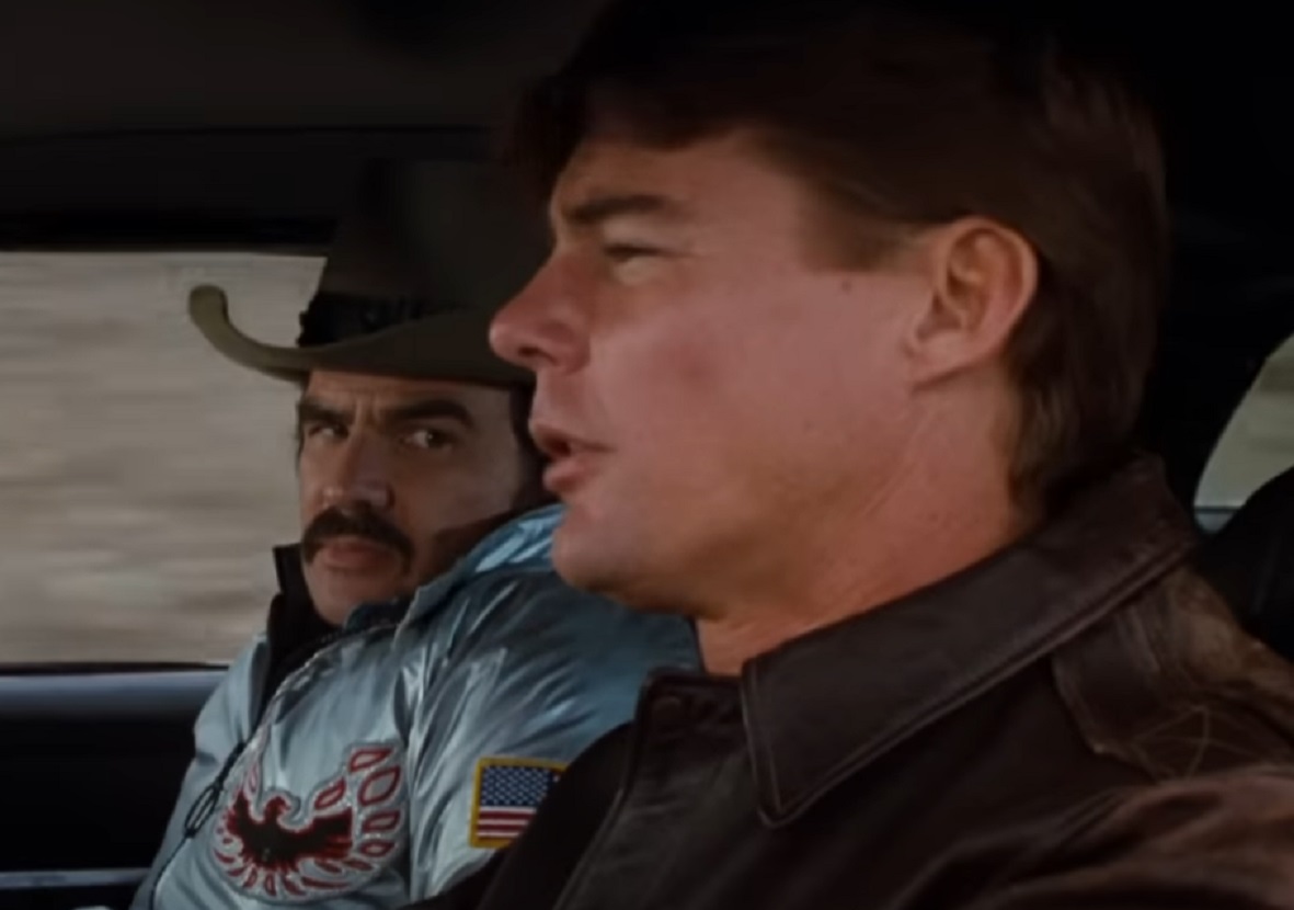 Screenshot: Jan-Michael Vincent wearing black jacket is driving a car - from Hooper (1978)