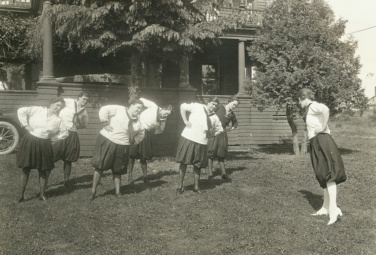 Grayscale photo of Victorian era women having physical exercise wearing middies and bloomers