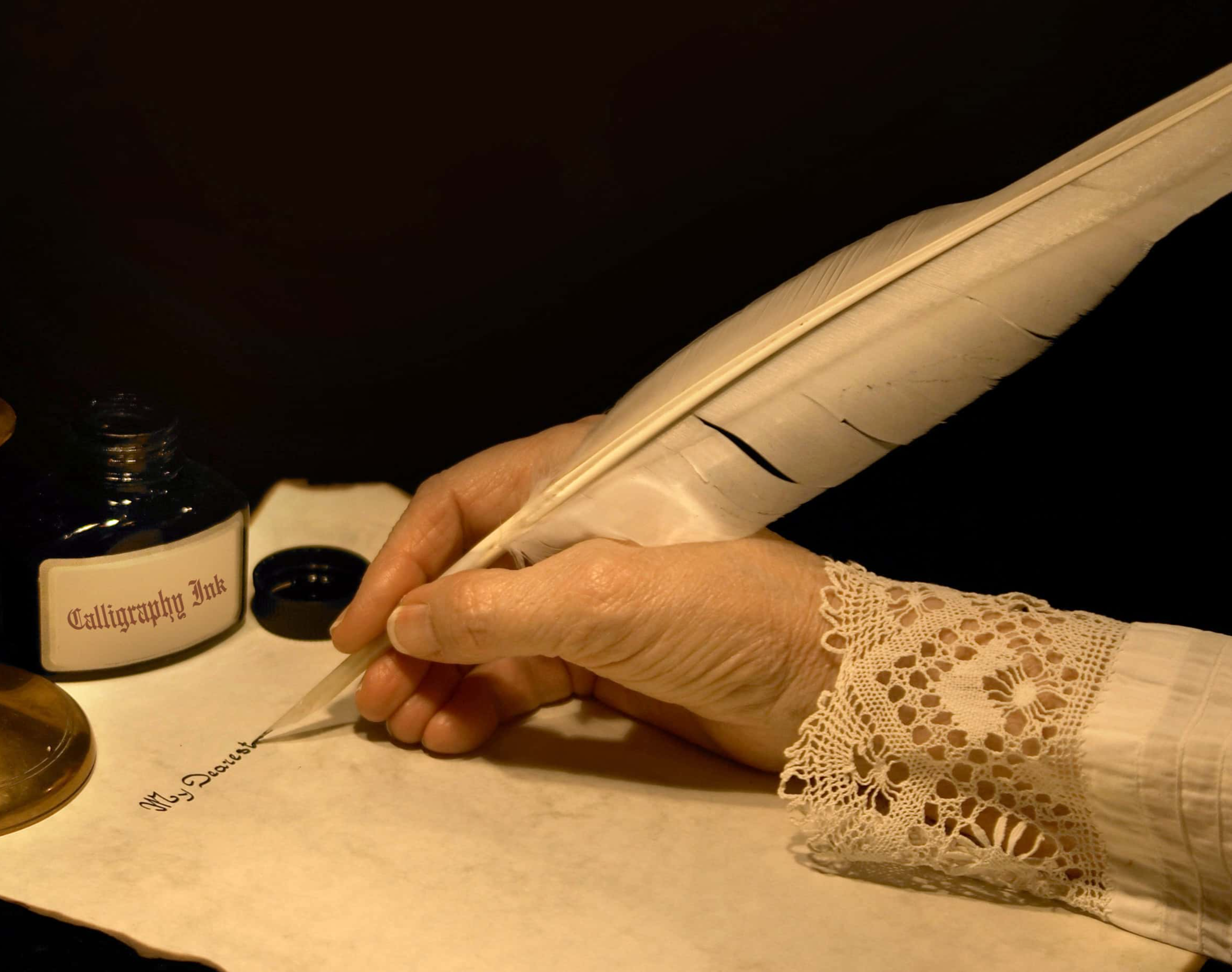 Hand writing a letter with a goose feather