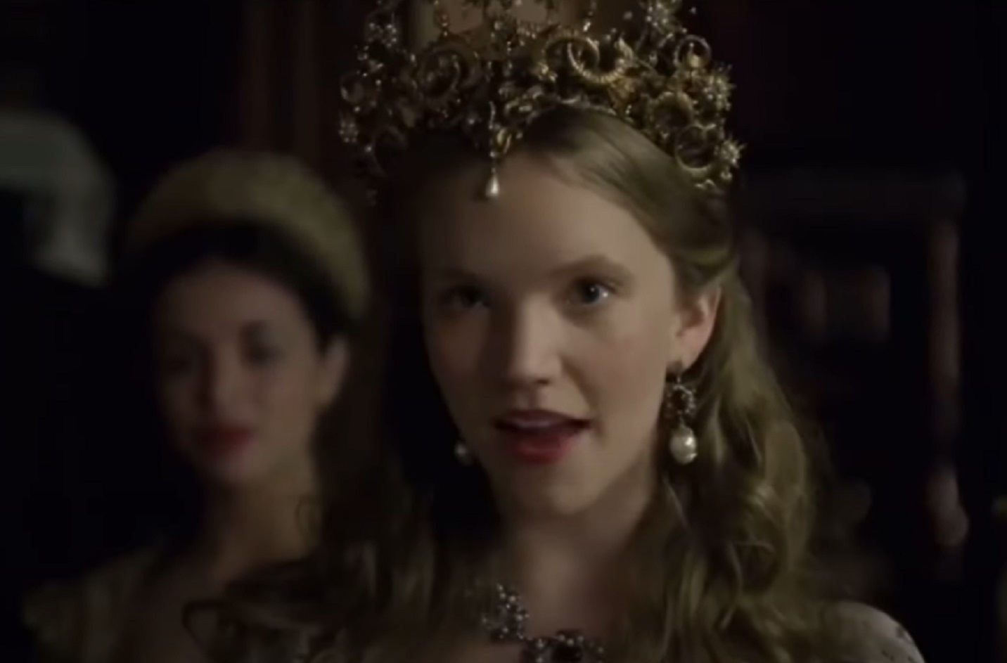 Screenshot of Catherine Howard with long hair wearing pearl earrings is looking at front - from The Tudors (2007–2010)