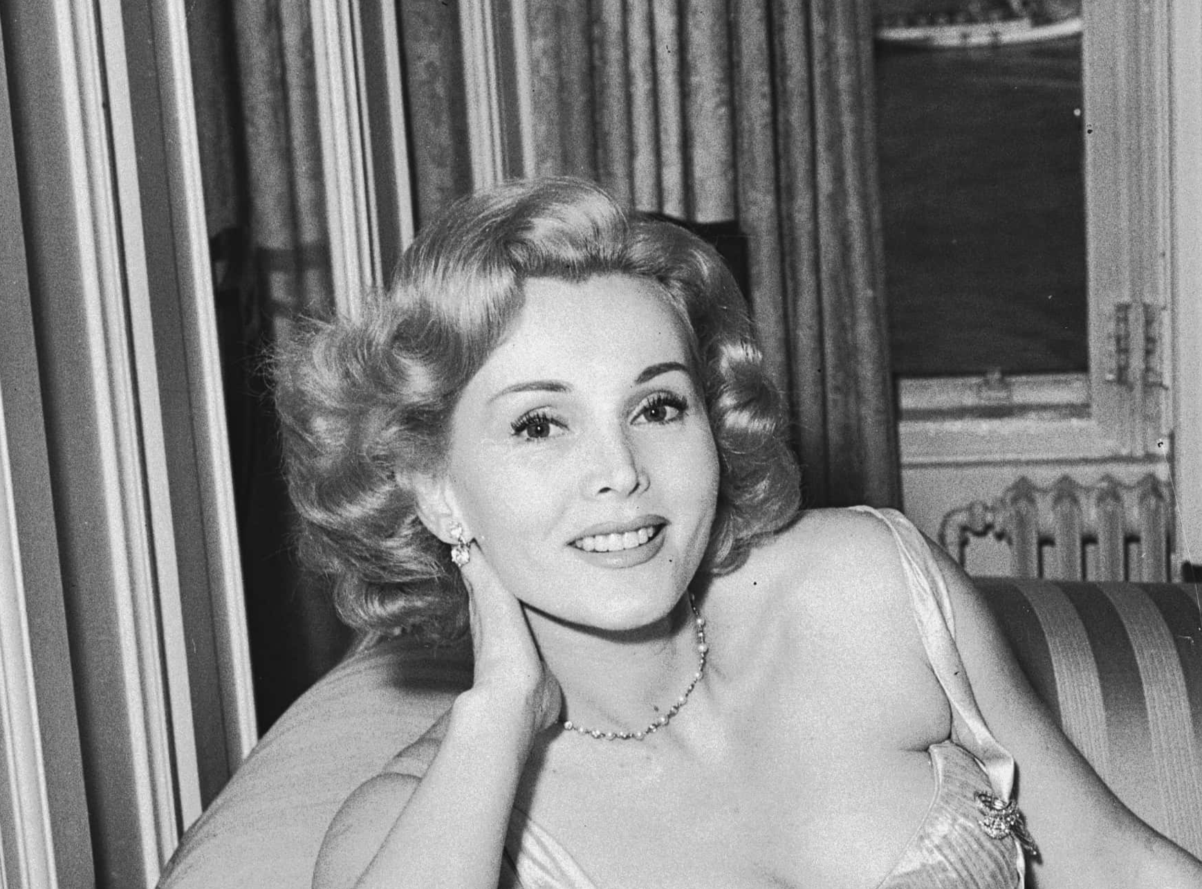 Zsa Zsa Gabor sitting on a couch