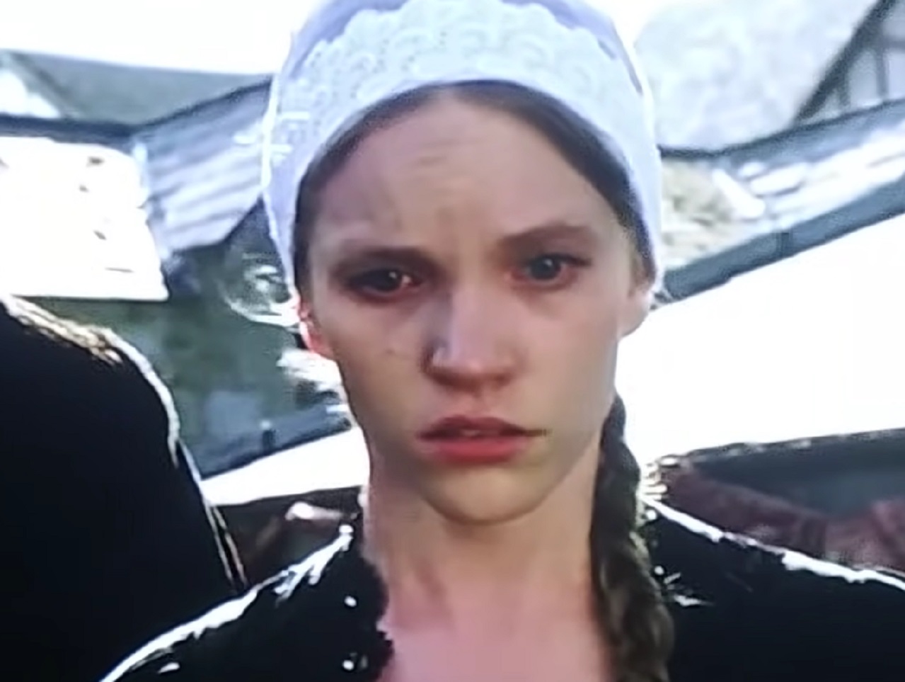 Screenshot of Catherine Howard with black coat walking outside with sad face - from The Tudors (2007–2010)