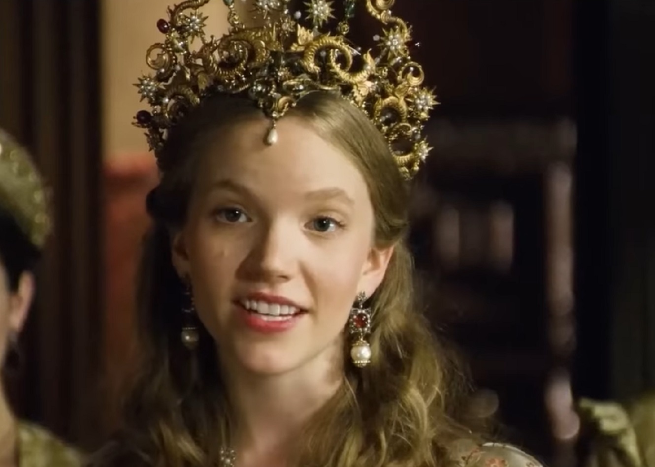 Screenshot of Catherine Howard with long hair wearing pearl earrings and crown is looking at front - from The Tudors (2007–2010)