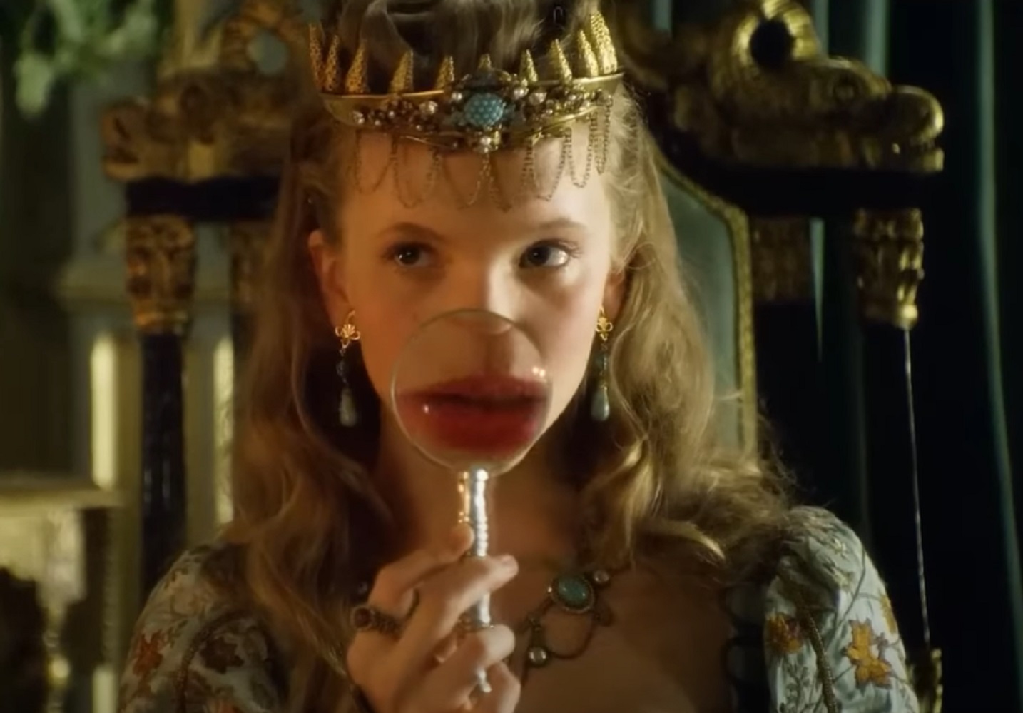 Screenshot of Catherine Howard with long hair holding a magnifying glass in front of her face - from The Tudors (2007–2010)