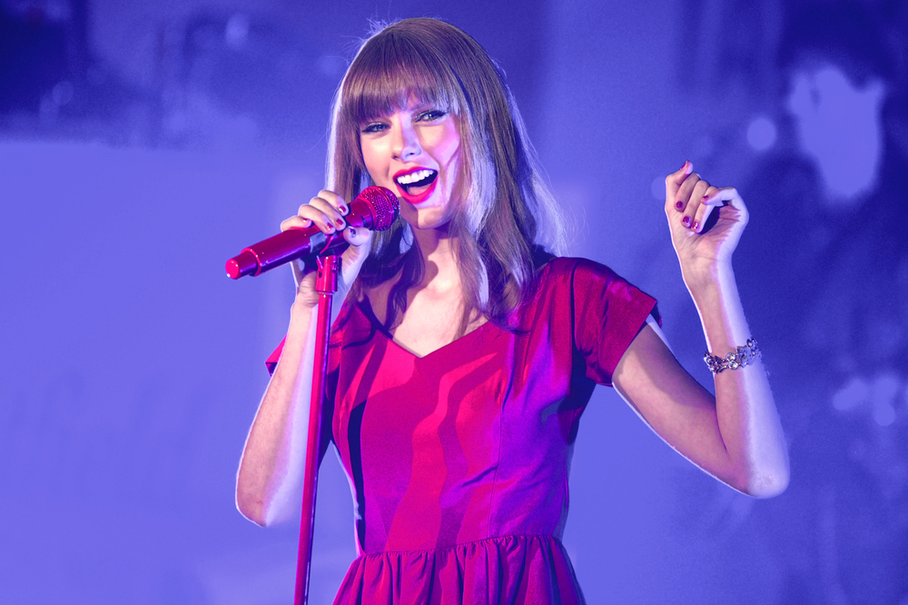 Taylor Swift performs and turns on the Christmas Lights at Westfield Shepherd's Bush, London, wears red dress
