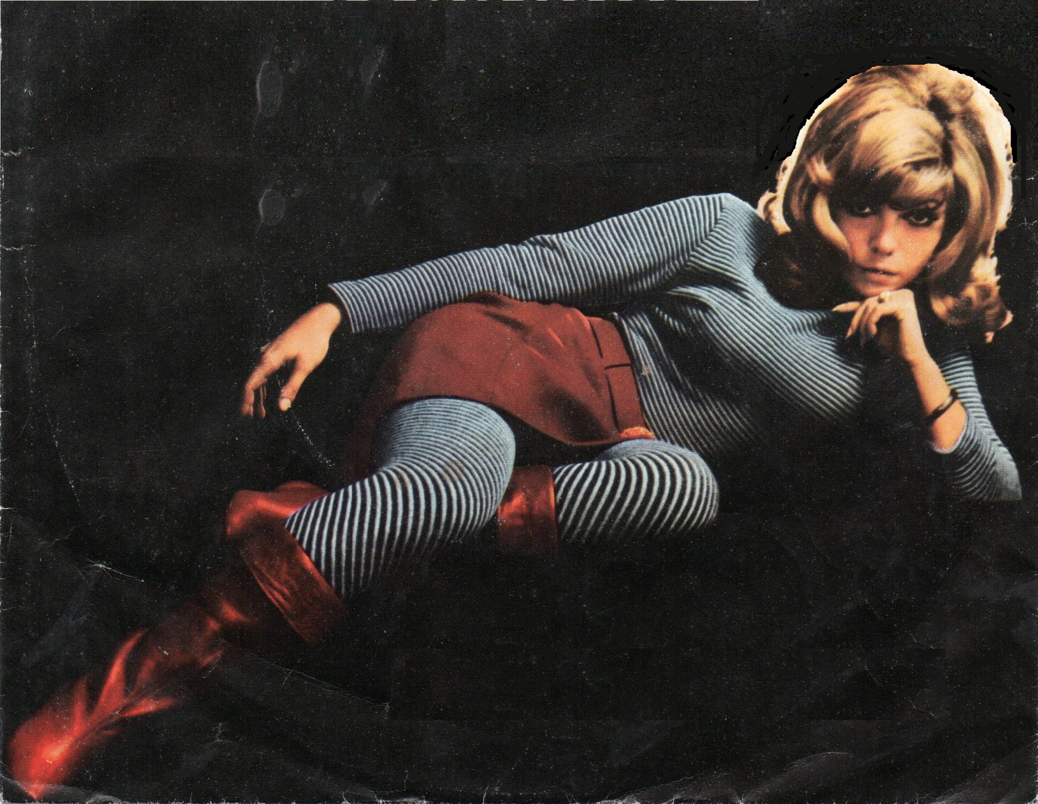 Image of Nancy Sinatra wearing grey and red clothes.