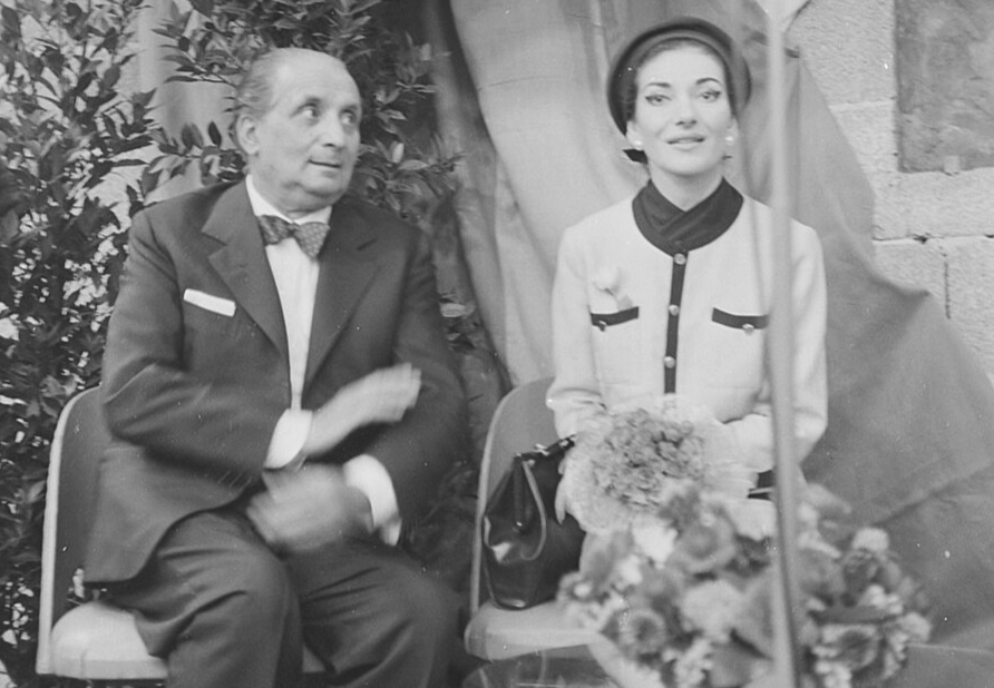 Grayscale Portrait Photo of Maria Callas and Giovani Battista Meneghini, sitting next to each other