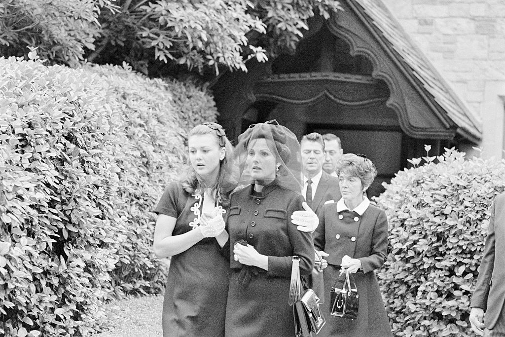 Ursula Thiess, widow of actor Robert Taylor (C) is comforted by her daughter, Manuela Thiess (L), as they leave the Church