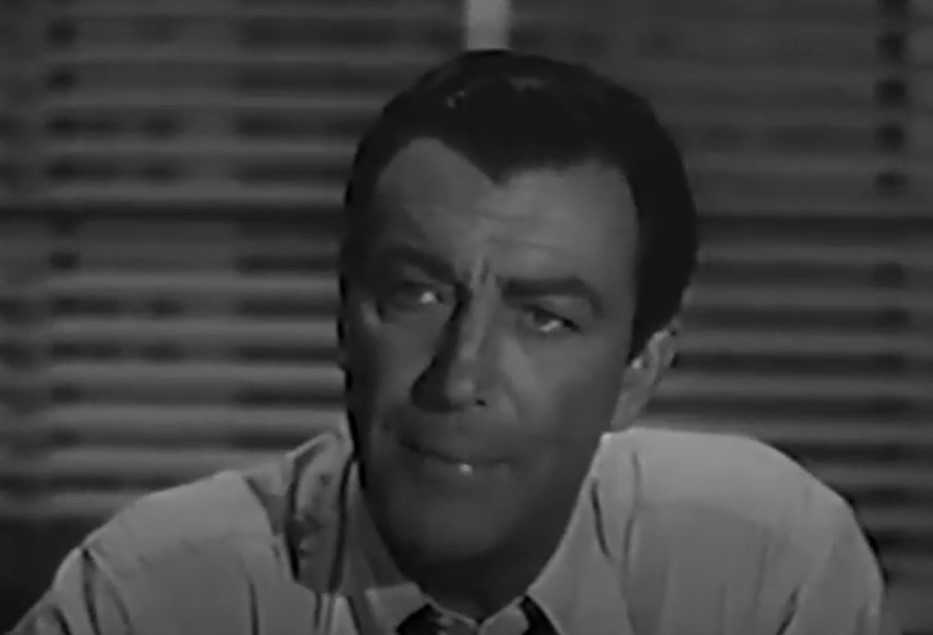 Robert Taylor  in the The Detectives wearing a shirt sitting at a desk
