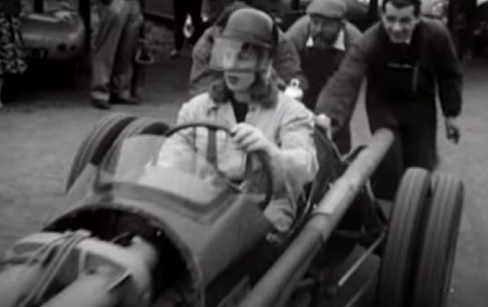 Screenshot: Roberta Cowell wearing helmet is driving a racing car - from Secret History - The Sex Change Spitfire Ace (2015)