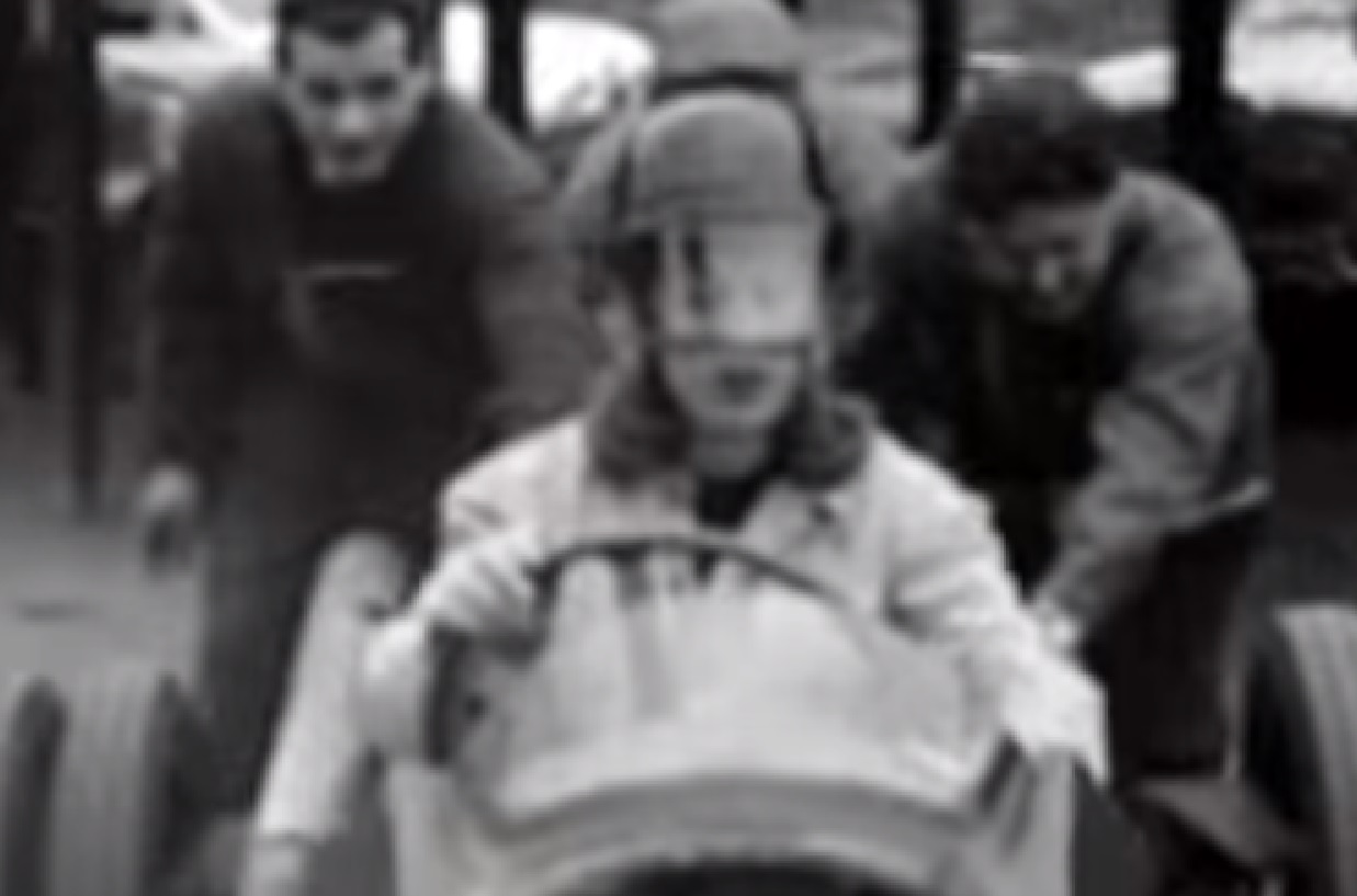 Screenshot: Roberta Cowell wearing helmet is driving a racing car - from Secret History - The Sex Change Spitfire Ace (2015)