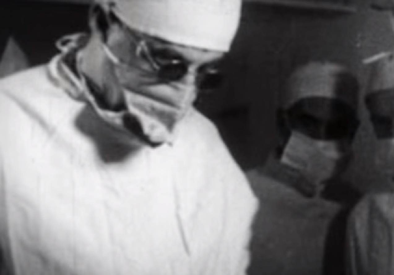 Screenshot: Doctor making a surgery in O. Room - from The Sex Change Spitfire Ace (2015)