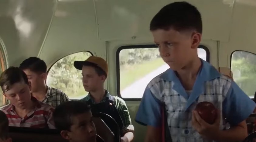 Young Forrest Gump walking in school bus