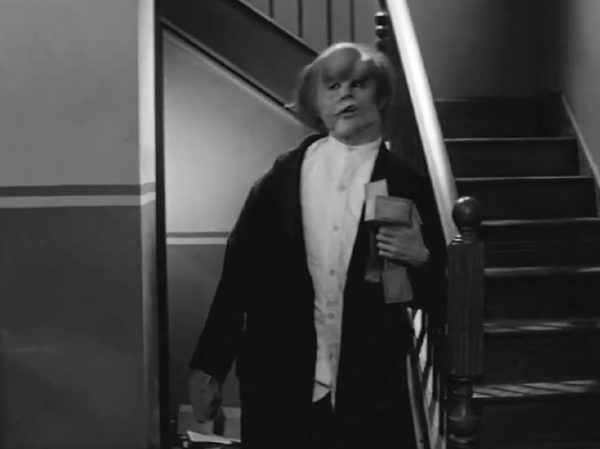B&W Screenshot of Joseph Merrick (John Hurt) walking at hallway - from Elephant Man (1980)