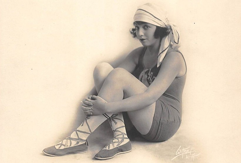 1918 portrait of American actress Bebe Daniels sitting on the floor wearing sports outfit