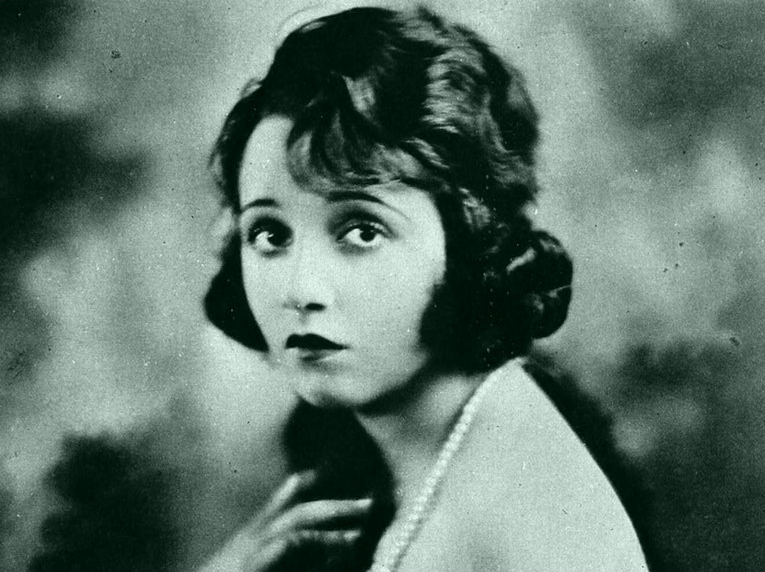 Grayscale Portrait of Bebe Daniels by photographer Albert Witzel wearing a dark colored dress