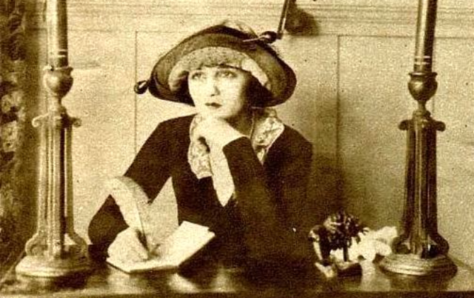 Actress Bebe Daniels in a corner of her suite at a converted house on the Realart Studio lot in Hollywood wearing a black dress