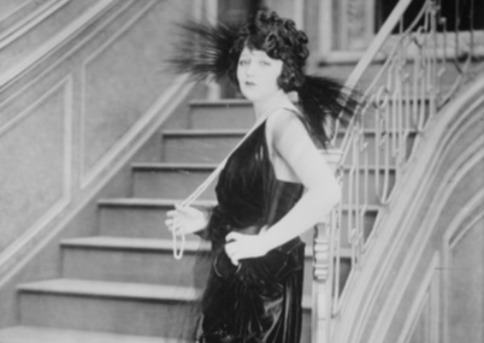 Grayscale Photo of the Actress Bebe Daniels wearing a black dress and a hat