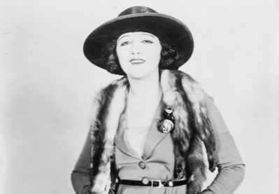 Grayscale Photo of the Actress Bebe Daniels wearing a coat and a black hat