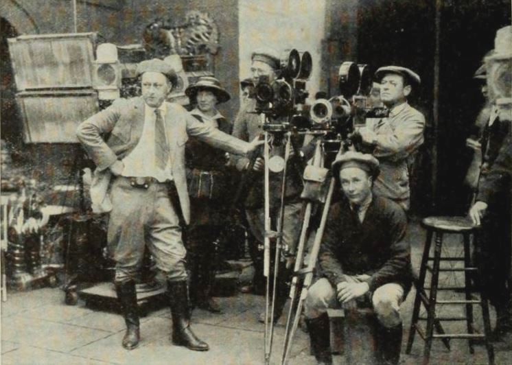 Director Cecil B. DeMille on a Movie set surrounded with coworkers