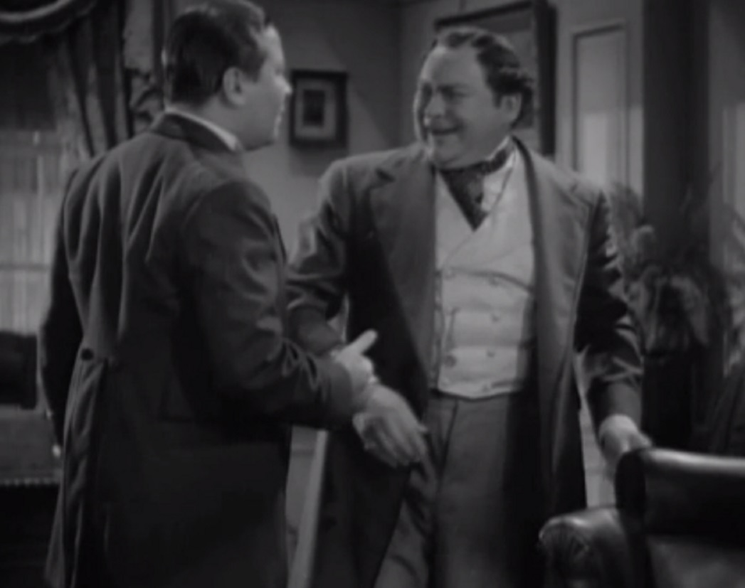 Screenshot of James Fisk (Edward Arnold) wearing suit and talking with other man- from The Toast of New York (1937)