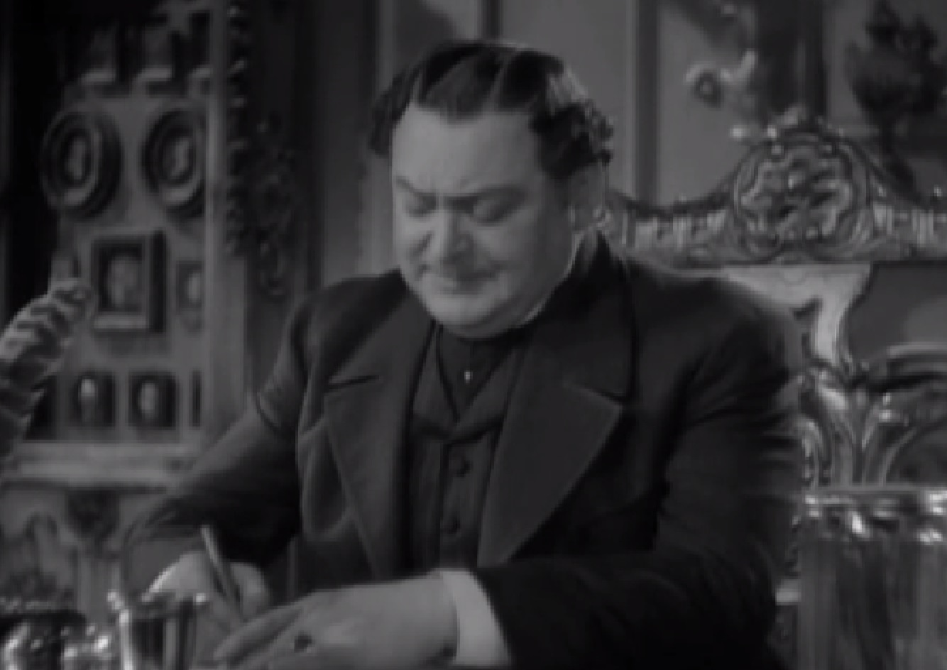 Screenshot of James Fisk (Edward Arnold) writing a letter on his desk - from The Toast of New York (1937)