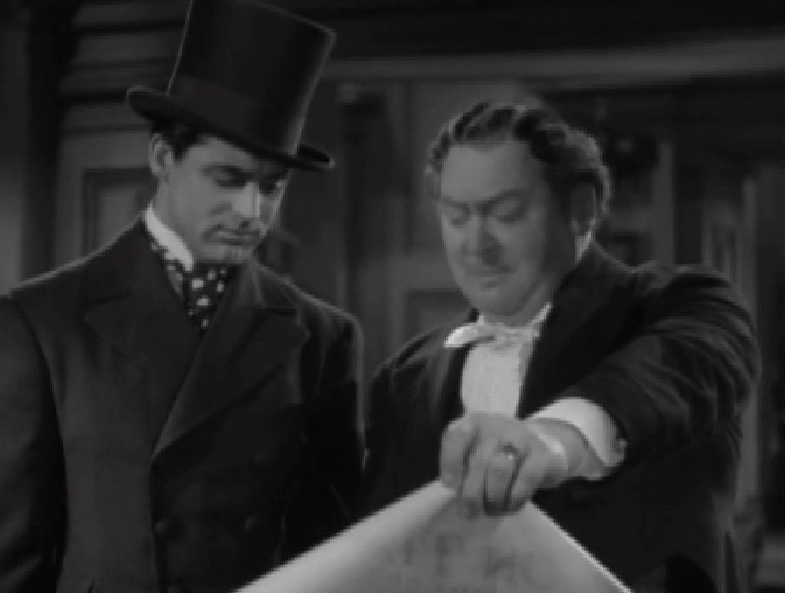 Screenshot of James Fisk (Edward Arnold) wearing suit is looking at blueprint - from The Toast of New York (1937)