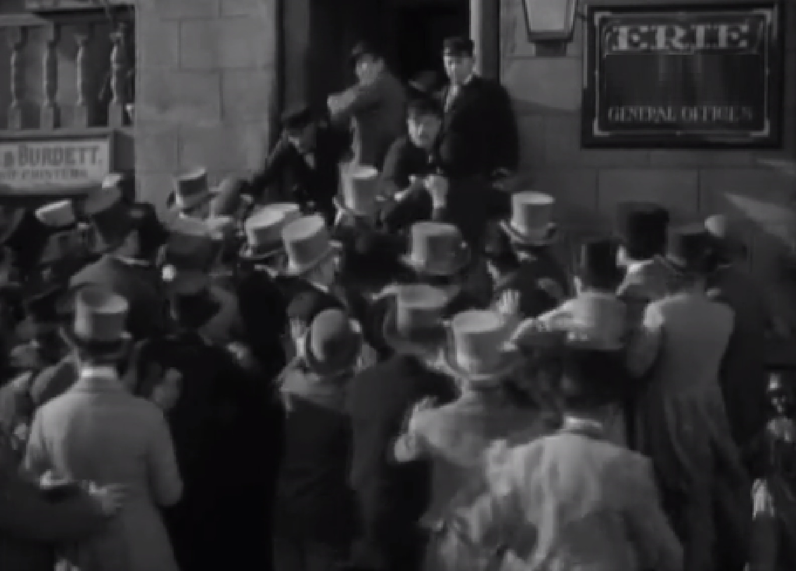 Screenshot of angry people trying to enter in the building - from The Toast of New York (1937)