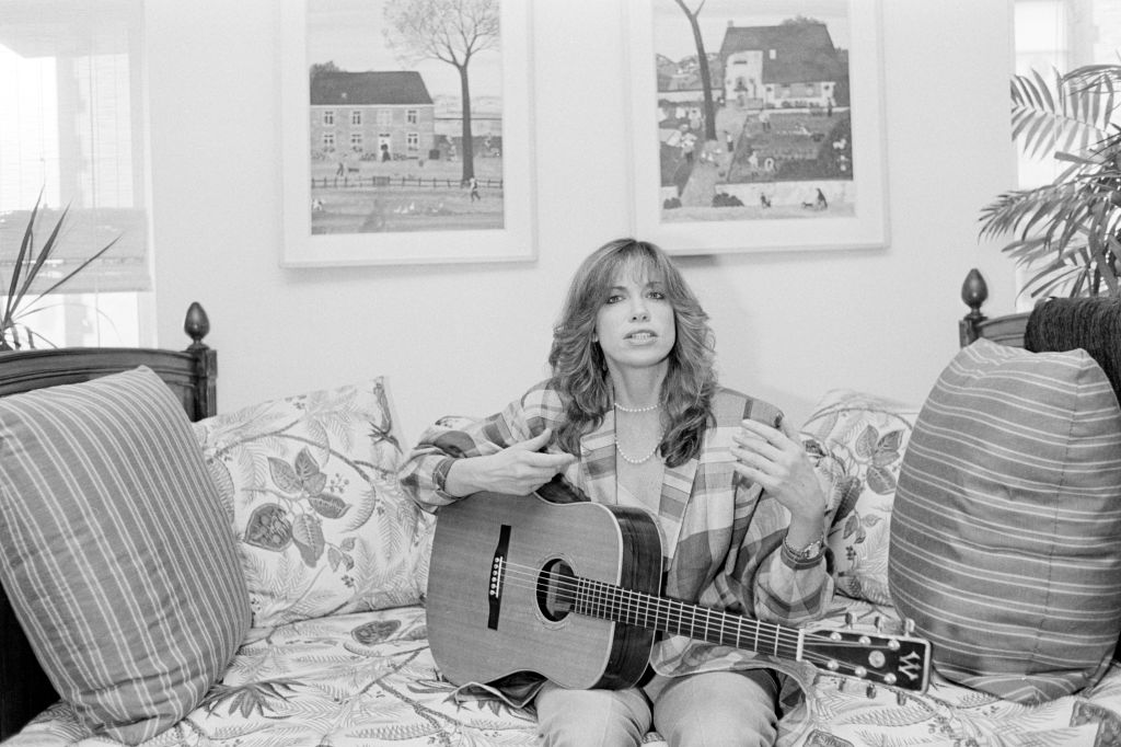 Singer Carly Simon sitting at home
