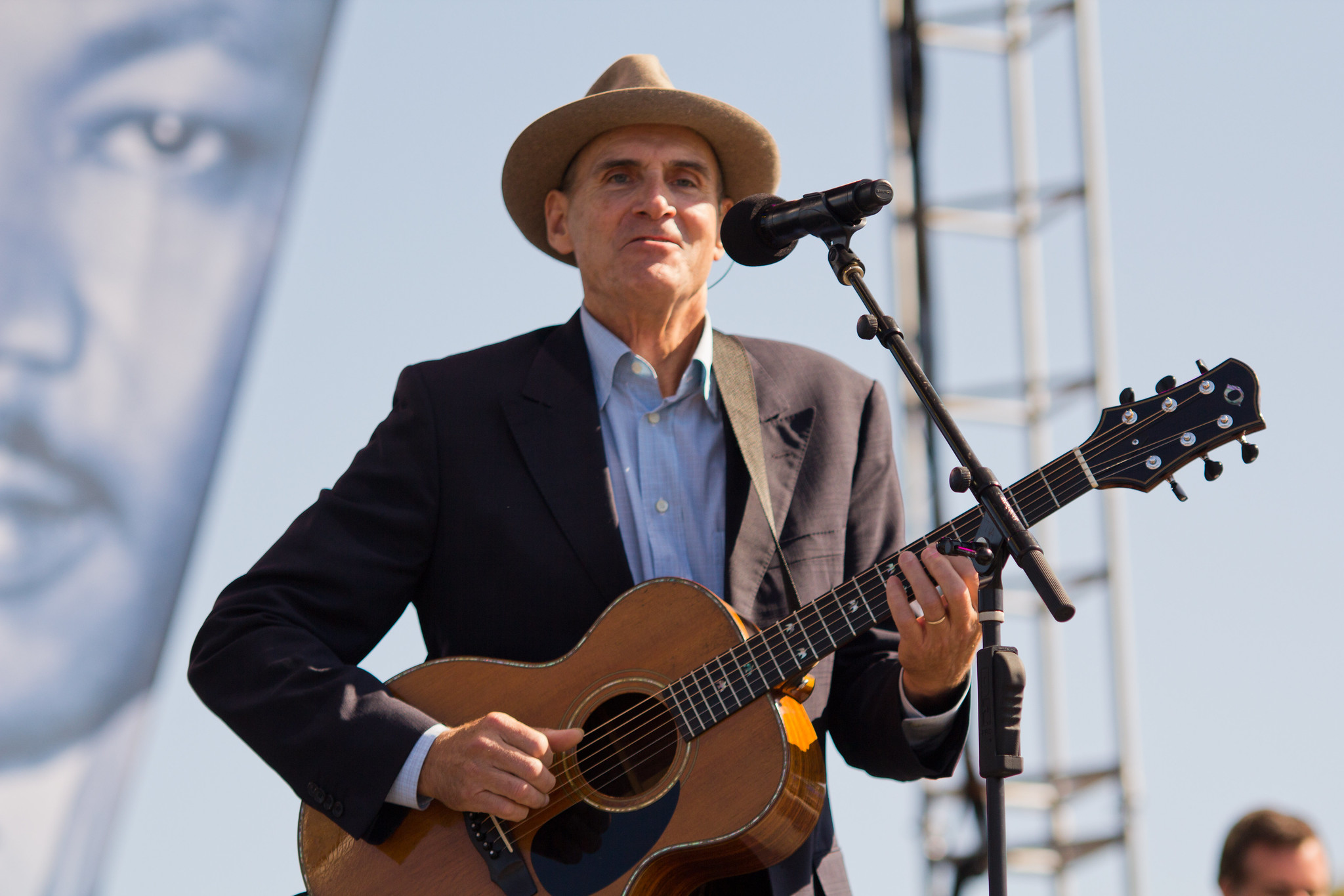 James Taylor wearing jacket and hat is performing outside - 2011