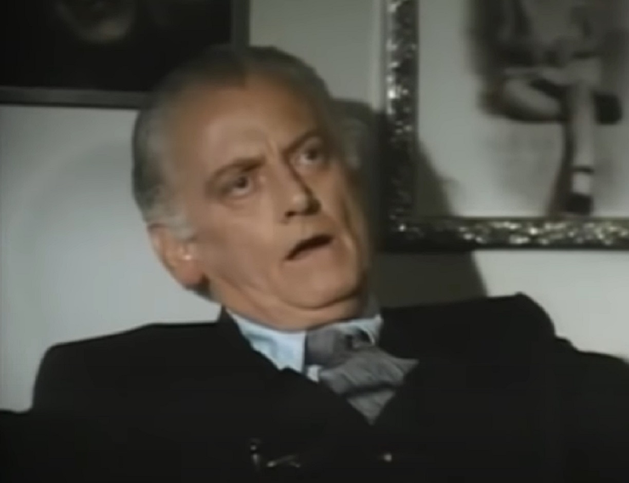 Screenshot of Art Carney wearing black suit and looking at side - from Katherine (1975)